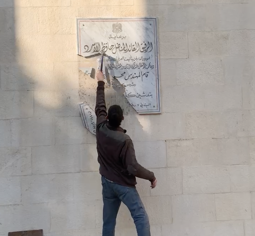 Fine Arts student in Damascus breaks a plaque bearing Hafez al-Assad’s name 9_12_2024. Foto courtesy Mahmoud Arroub